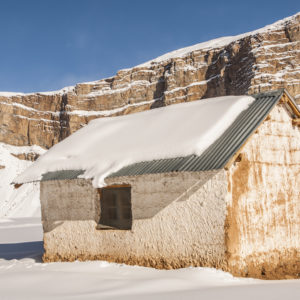 A house against the backdrop of a streaked mountain